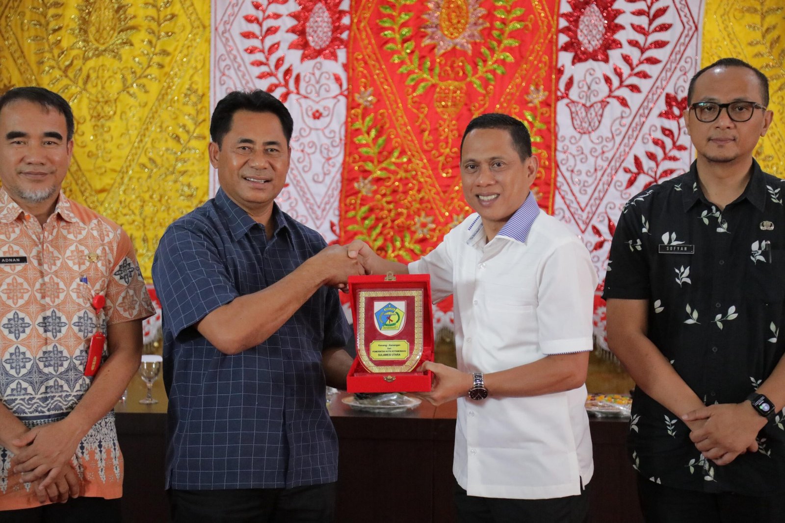 Wali Kota Kotamobagu, Weny Gaib menyerahkan pataka tanda menerima kunjungan kerja rombongan Bupati Halmahera Timur, Drs Ubaid Yakub di Kotamobagu, Jumat (1/8/2025). Foto/Kominfo Kotamobagu.