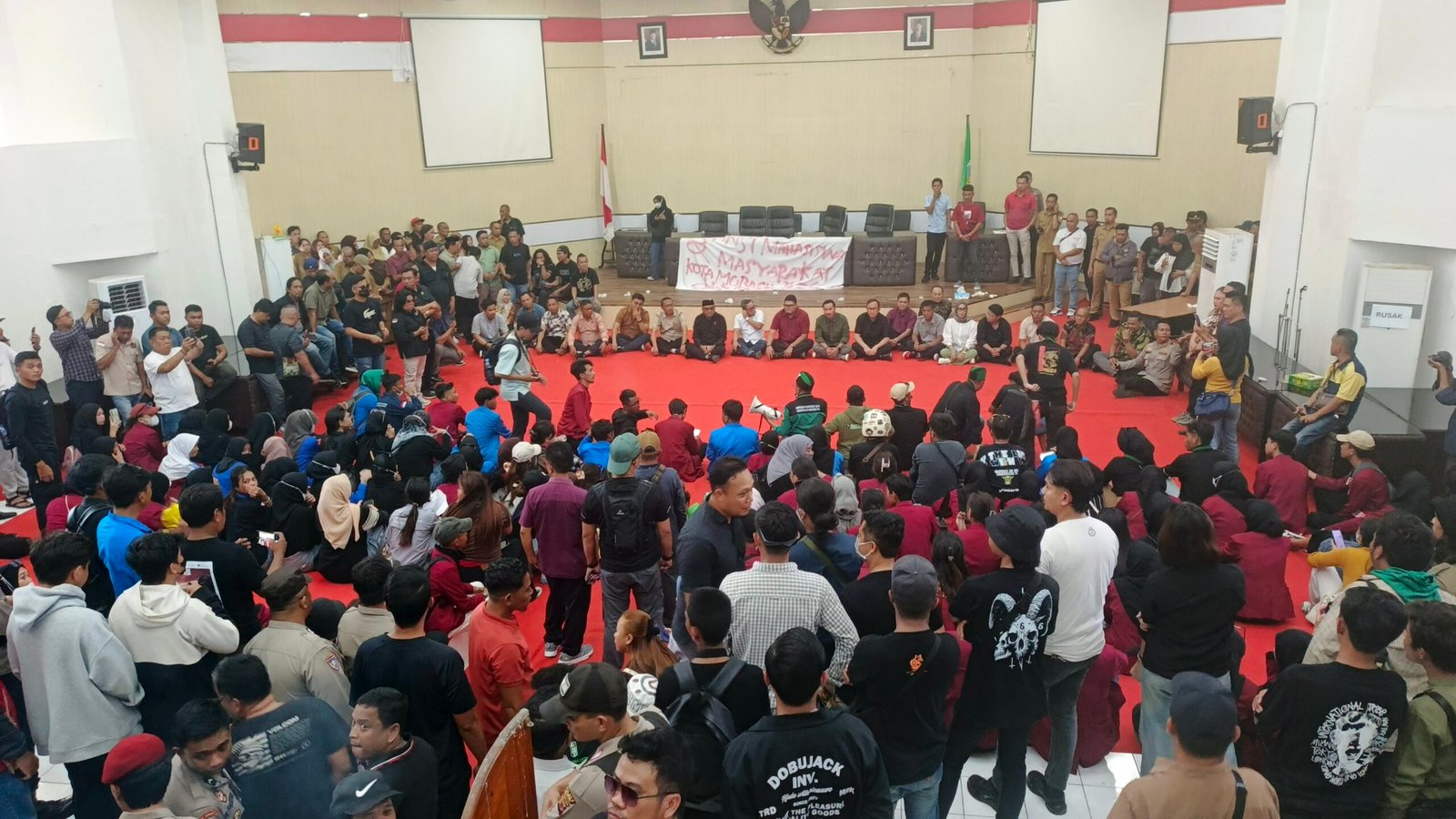 Aliansi Mahasiswa Kotamobagu berorasi di dalam Ruang Paripurna DPRD Kotamobagu, menyampaikan sejumlah tuntutan. Foto/Rafsan.
